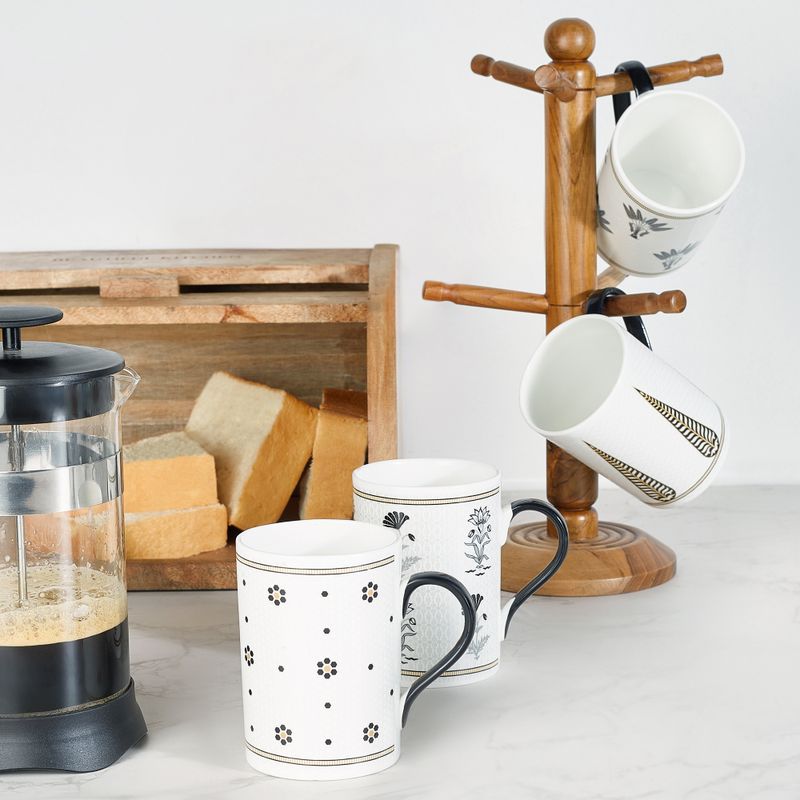 Cuisine élégante avec une cafetière à piston, des mugs décoratifs et du pain frais.