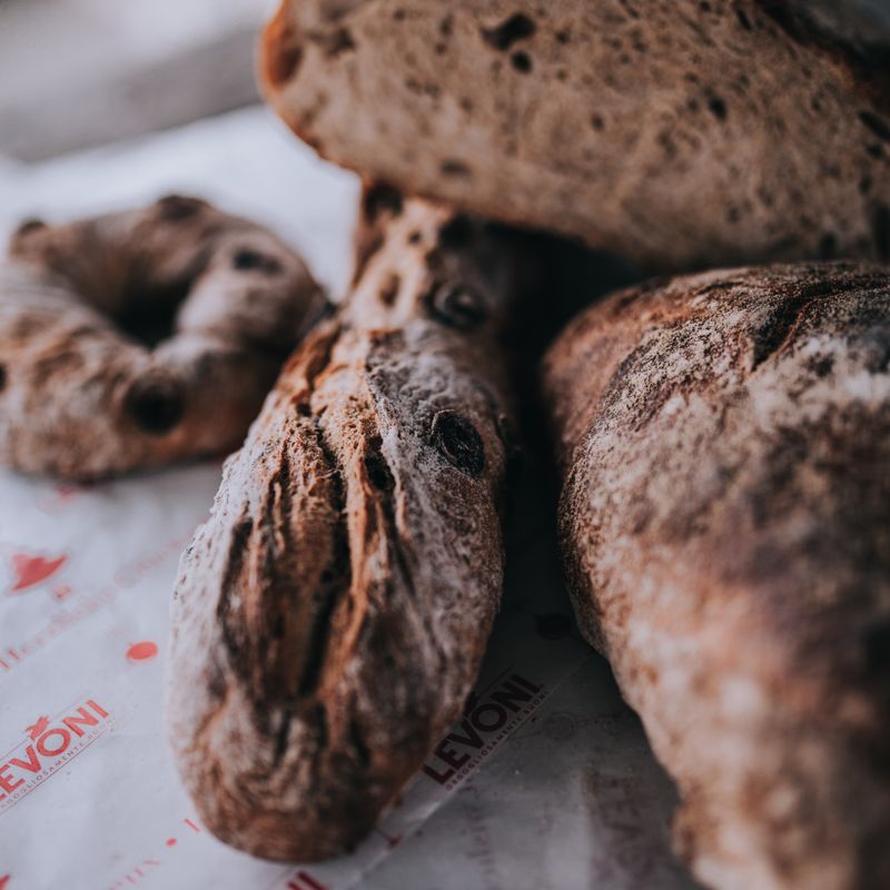 Gros plan sur un pain au levain artisanal, mettant en valeur sa croûte dorée et sa mie alvéolée.