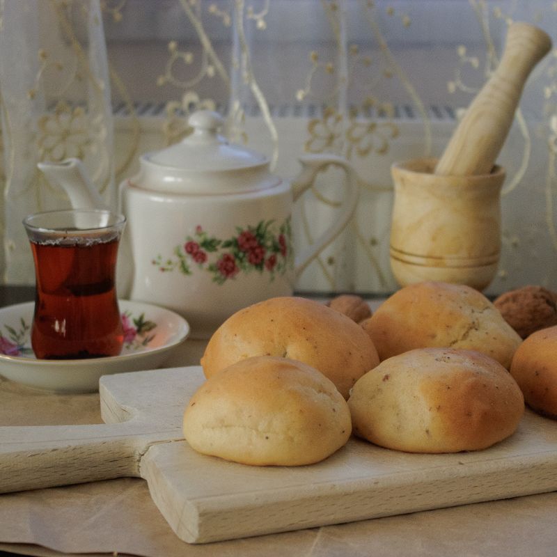 Service à thé chaud avec des petits pains moelleux et une théière élégante.